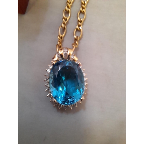 4 - 14 KT gold pendant set with a large blue stone surround by diamonds 18.3 g (3.4 cms x 2.3 cms) on a ... 