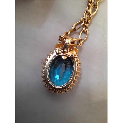 4 - 14 KT gold pendant set with a large blue stone surround by diamonds 18.3 g (3.4 cms x 2.3 cms) on a ... 