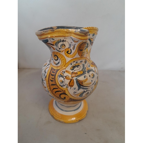 6 - An antique Italian polychrome maiolica jug with floral decoration, with fritting and note cracked an... 