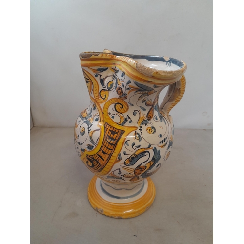 6 - An antique Italian polychrome maiolica jug with floral decoration, with fritting and note cracked an... 