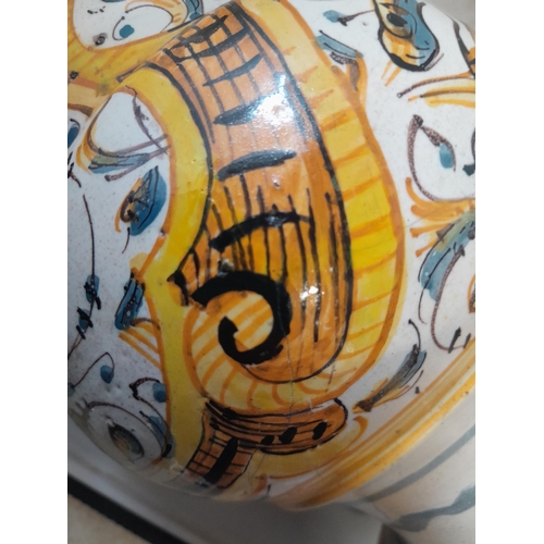 6 - An antique Italian polychrome maiolica jug with floral decoration, with fritting and note cracked an... 