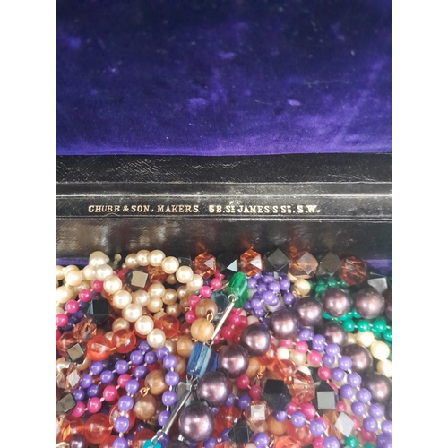 50 - A collection of costume jewellery in a Victorian Chubb box with key : necklaces, brooches, small amo... 