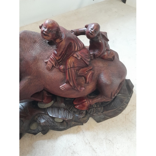 58 - Early 20th century well carved Chinese hardwood figure group of Children sat astride recumbent  buff... 