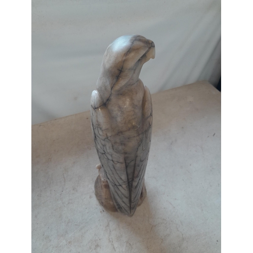 136 - Early 20th century carved marble eagle ornament with glass eyes  with later baize on base 35 cms