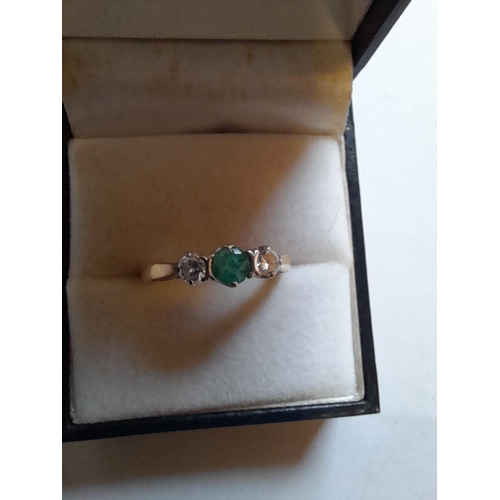 67 - 18 ct gold ring set with single emerald and two diamonds size Q,