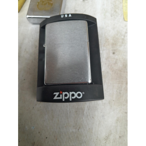 104 - Zippo and Zippo style petrol lighters, 2 in boxes of issue, earlier models noticed