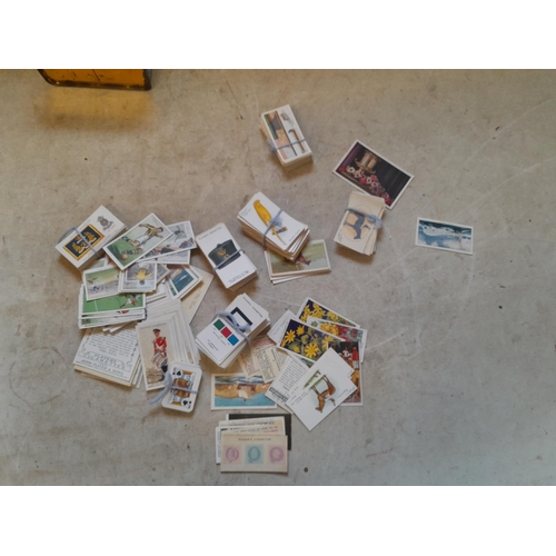 119 - World War I era silk cards & comedy cards and a tin of cigarette cards, mainly Players, packeted by ... 