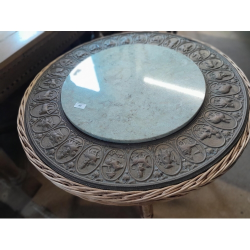 49 - An interesting vintage Indian wicker table with hardstone panel and repouse work brass relief of pan... 