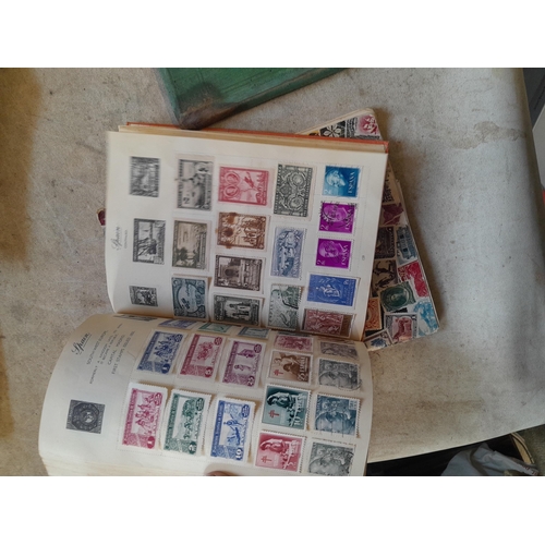 136 - Stamps: a box of stamps albums, ice cream carton of stamps on paper and loose, mixed era world stamp... 