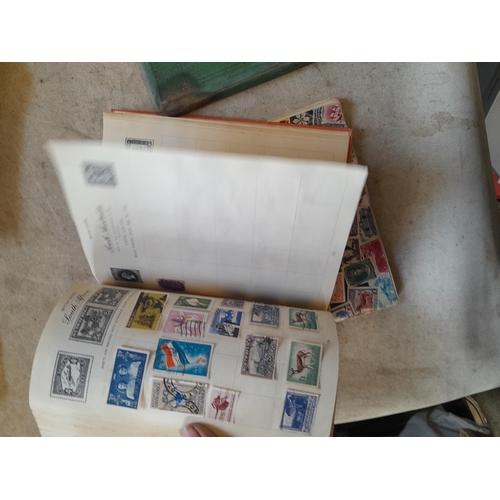 136 - Stamps: a box of stamps albums, ice cream carton of stamps on paper and loose, mixed era world stamp... 