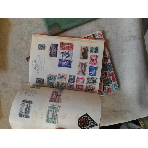 136 - Stamps: a box of stamps albums, ice cream carton of stamps on paper and loose, mixed era world stamp... 