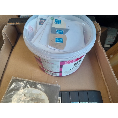 136 - Stamps: a box of stamps albums, ice cream carton of stamps on paper and loose, mixed era world stamp... 