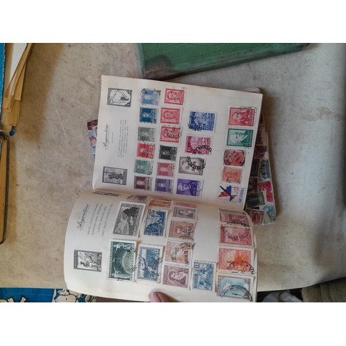 136 - Stamps: a box of stamps albums, ice cream carton of stamps on paper and loose, mixed era world stamp... 
