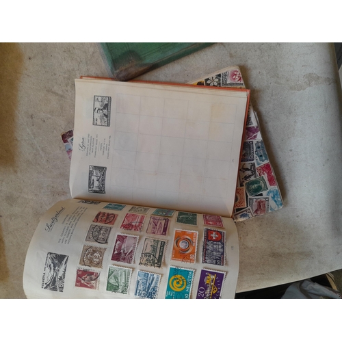 136 - Stamps: a box of stamps albums, ice cream carton of stamps on paper and loose, mixed era world stamp... 
