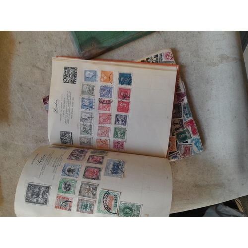 136 - Stamps: a box of stamps albums, ice cream carton of stamps on paper and loose, mixed era world stamp... 