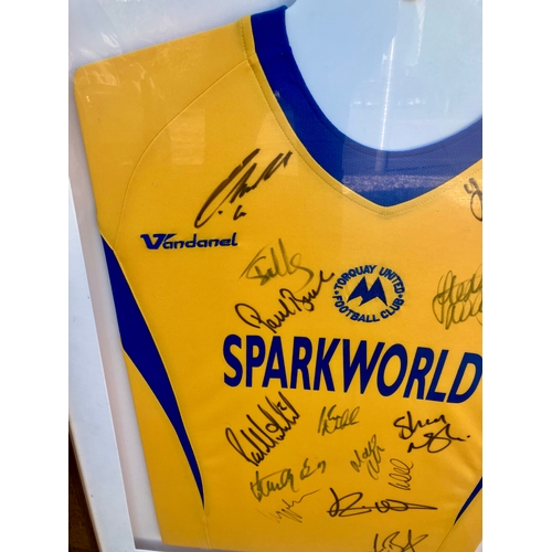 231 - Signed Torquay United Football shirt behind perspex