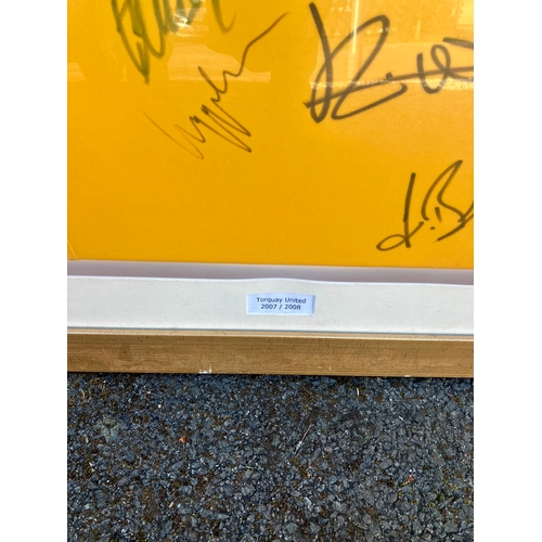 231 - Signed Torquay United Football shirt behind perspex