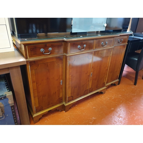 534 - Yew Breakfront Sideboard with Three Drawers, Four Cupboards and Glass Top Overlay.