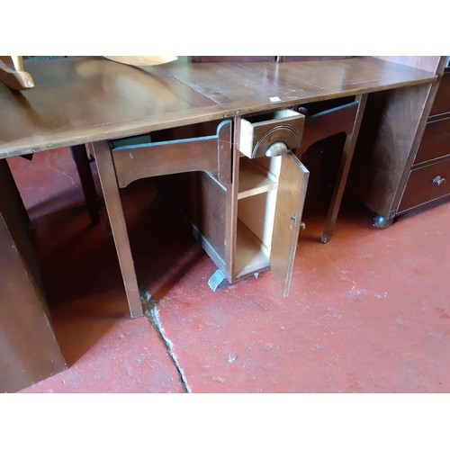 495 - Drop Leaf Oak Dining Table with Central Storage Door and Cupboard.