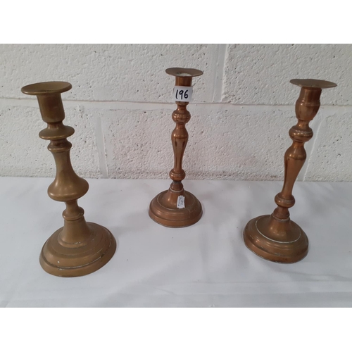 196 - Three Brass Candlesticks.