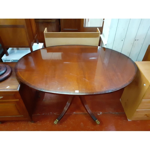 532 - Oval, Inlaid Mahogany, Drop Leaf, Pedestal Dining Table with Outstretched Brass Claw Feet.