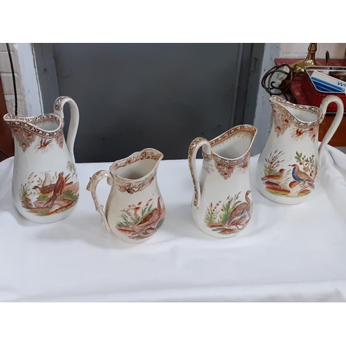 354 - Four Vintage Brown Swansea Bird Scene Graduated Jugs - some have chips.