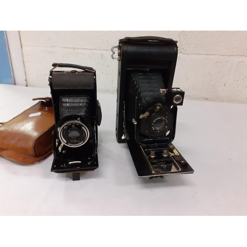 212 - Two Vintage Folding Cameras - Voigtlander & Carbine.