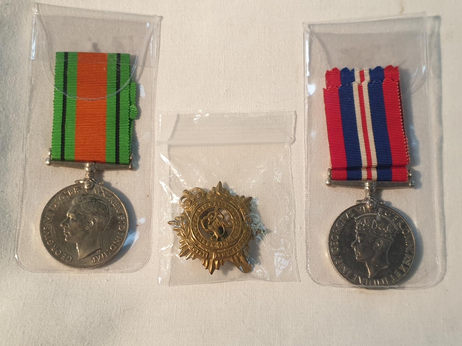 Two World War Two Campaign Medals & Royal Army Corps Cap Badge.