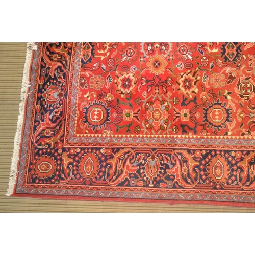 251 - A LATE 20TH CENTURY PERSIAN DESIGN WOVEN WOOL FLOOR CARPET having pigeon red ground central busy fie... 