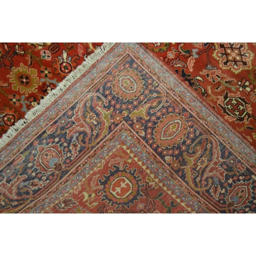 251 - A LATE 20TH CENTURY PERSIAN DESIGN WOVEN WOOL FLOOR CARPET having pigeon red ground central busy fie... 