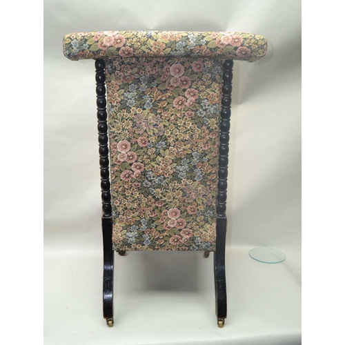 256 - A LATE VICTORIAN PRIE DIEU CHAIR, turned ebonised frame, on castors, with floral decorated upholster... 