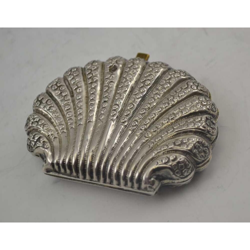 29 - A LATE 19TH CENTURY CONTINENTAL WHITE METAL SCALLOP FORM PURSE with embossed decoration, pink fabric... 