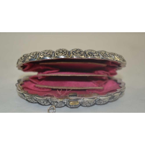 29 - A LATE 19TH CENTURY CONTINENTAL WHITE METAL SCALLOP FORM PURSE with embossed decoration, pink fabric... 