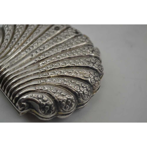 29 - A LATE 19TH CENTURY CONTINENTAL WHITE METAL SCALLOP FORM PURSE with embossed decoration, pink fabric... 