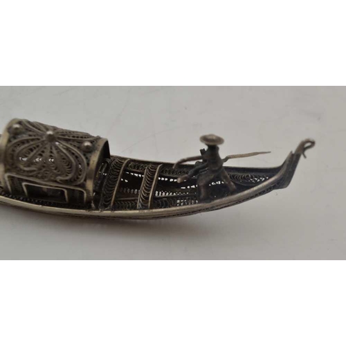 41 - AN EARLY 20TH CENTURY ITALIAN WHITE METAL MODEL OF A GONDOLA, with hinged compartment, 15cm long ... 