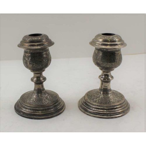 52 - A PAIR OF PERSIAN SILVER CANDLESTICKS, overall chased decoration, bear various stamped marks, c.1900... 