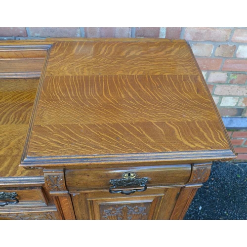 321 - AN ART NOUVEAU DESIGN OAK SIDEBOARD, tiwn pedestal design, with carved panel decoration, fitter thre... 