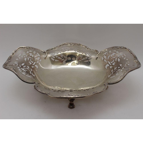 10 - An early 20th century silver bread basket, shaped rim, pierced decoration, of oval form, raised on f... 