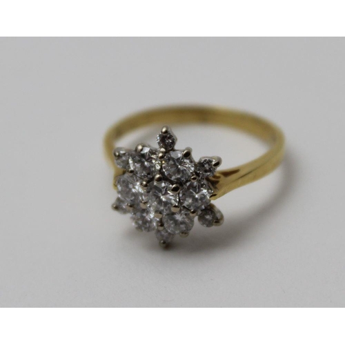 65 - A diamond cluster ring, flower head form, brilliant cut central stone, surrounded by six diamonds wi... 