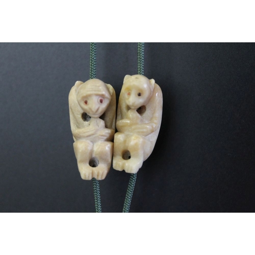 124 - An early to mid 20th century Chinese monkey necklace, the green chard is strung with ten carved ston... 