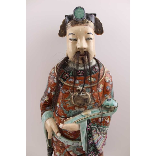 85 - An early 20th century Chinese ceramic Immortal, carrying a Ruyi sceptre, polychrome painted in an el... 