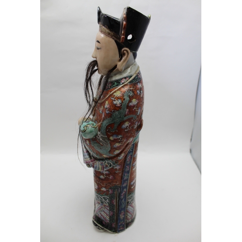 85 - An early 20th century Chinese ceramic Immortal, carrying a Ruyi sceptre, polychrome painted in an el... 