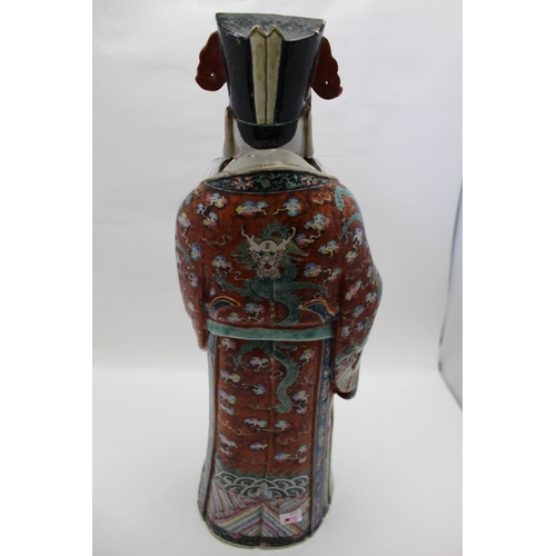 85 - An early 20th century Chinese ceramic Immortal, carrying a Ruyi sceptre, polychrome painted in an el... 