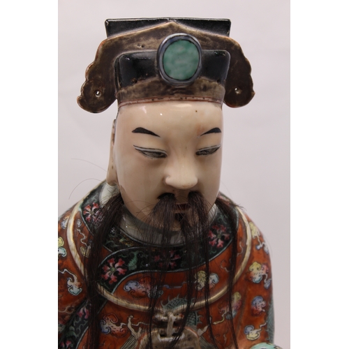 85 - An early 20th century Chinese ceramic Immortal, carrying a Ruyi sceptre, polychrome painted in an el... 