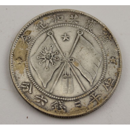 480 - A Chinese silvered coin, a portrait to one side, and crossed flags to the other, 32mm in diameter