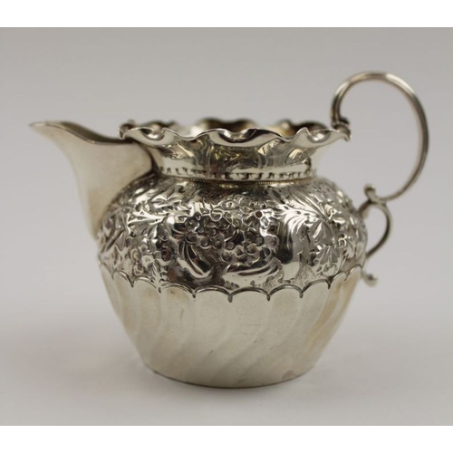 92 - Nathan & Hayes, a late 19th century embossed silver cream jug, with C scroll handle, Birmingham 1892... 