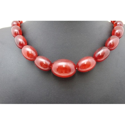 110 - A cherry amber bakelite graduated necklace, 88cm long. weight 88g.