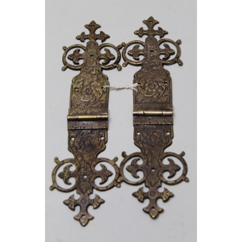 112 - A collection of twelve engraved and pierced brass hinges 21cm long