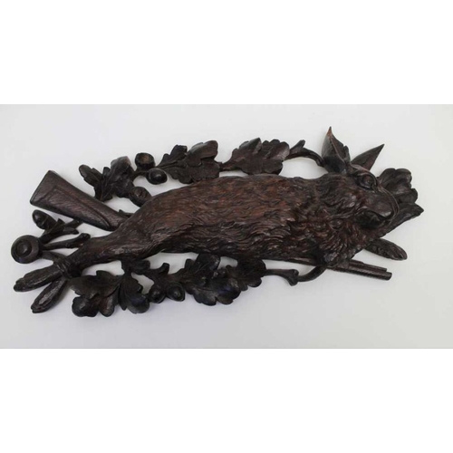 123 - A pair of 19th century Black Forest carved wall mounts, comprising a fox and a rabbit upon rifle and... 