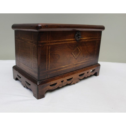 128 - A 19th century mahogany table casket, line inlay, on pierced platform base, the lid opens to reveal ... 